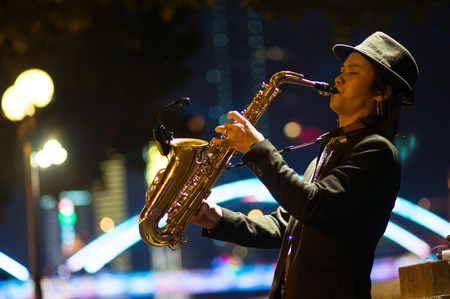 Guangzhou, China - MARCH 15, 2016: man playing saxophone on the street in the eveningのeditorial素材