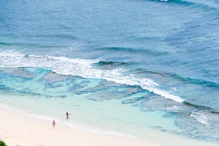 Two people on the sand beach oceanの写真素材