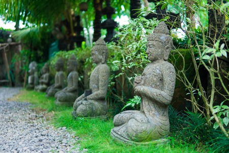 Stone religious sculpture covered by green moss in Goa Gajah Sanctuary. Bali, Indonesia