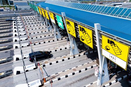 Toll roads on the broad highway. Through the point passes a large number of trucks and cars. Close up viewの写真素材