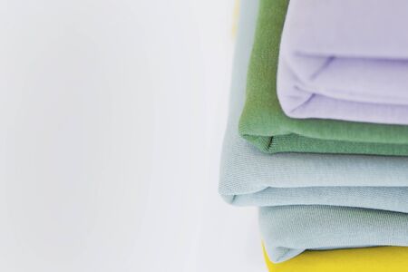 A stack of fabrics for sewing on the table. Multi-colored fabrics for tailoring. A pile of fabrics for sewing clothesの写真素材