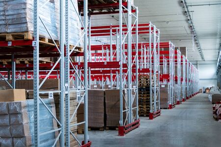 storage warehouse and racks on which there are cardboard boxes with finished productsの写真素材
