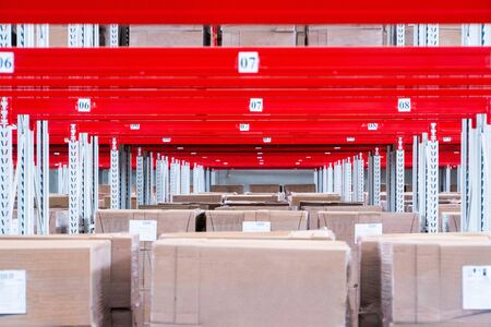 storage warehouse and racks on which there are cardboard boxes with finished productsの写真素材
