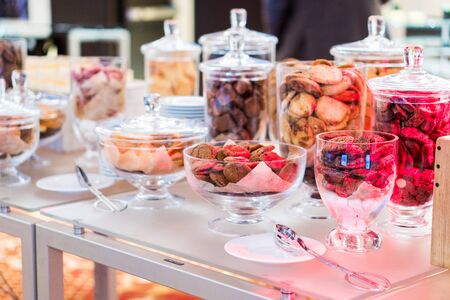 Shortbread cookies in glassware and other sweets on the buffet table during the coffee breakの写真素材