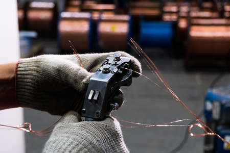 gloved hands connect the copper cable to the core with a special toolの写真素材