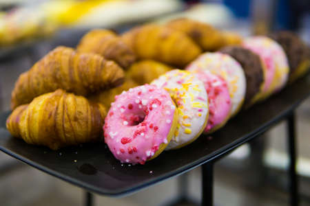 croissants, donut and other sweets on the buffet table during the coffee breakの写真素材