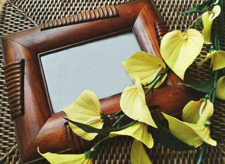 Wooden frame and yellow flowers on rattan coffee table
