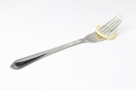 The condom is worn on a forkの写真素材