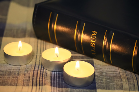 Dark blue photo album and three candles.の写真素材