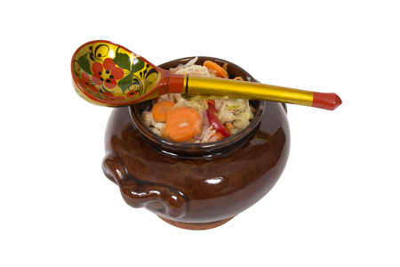 Russian sauerkraut in an earthenware jug. And a wooden spoon. Isolation on a white background. Clipping path.の写真素材