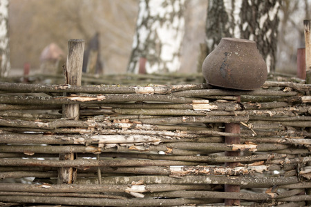 Country landscape  ?ast iron pot on wicker fence.の写真素材