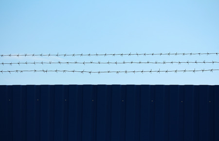 Imprisonment and freedom on opposite sides of the barbed wireの写真素材