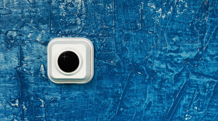 Background. Call button on the blue wall.
