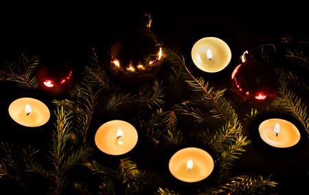New Year. Christmas balls and candles in the branches of spruce.の写真素材