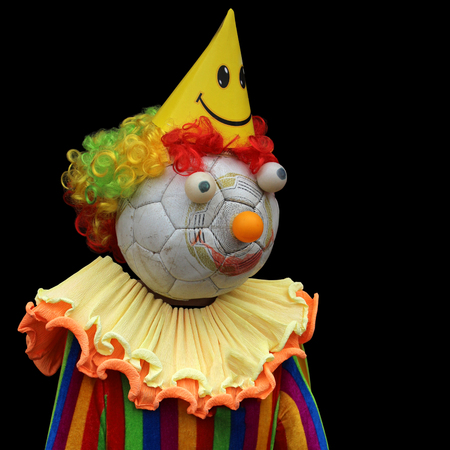 Fan. Funny handmade colorful doll clown made of an old soccer ball. Isolation on a black backgroundの写真素材