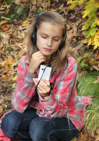 girl listening to music in the headset with a mobile phoneの写真素材