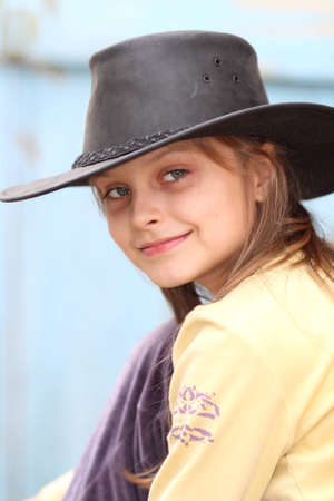 portrait of a beautiful girl in cowboy hat and a yellow t-shirtの写真素材