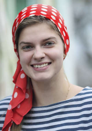 Cute smiling girl in red handkerchief and stripped tee shirtの写真素材