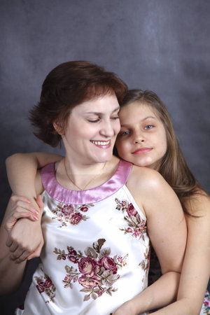 young girl and smiling young woman embrace each otherの写真素材