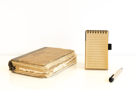 A craft-paper notebook with an old book on white backgroundの写真素材