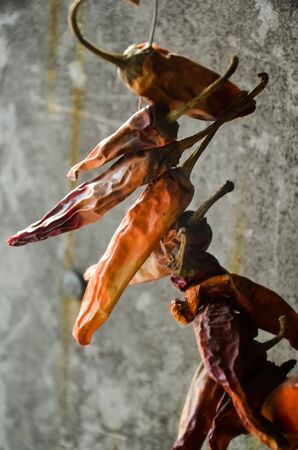 A bunch of dried red hot chili peppers on a gray wall background...の写真素材