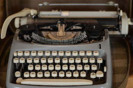 Old vintage typewriter on wooden table. Close-up photo.