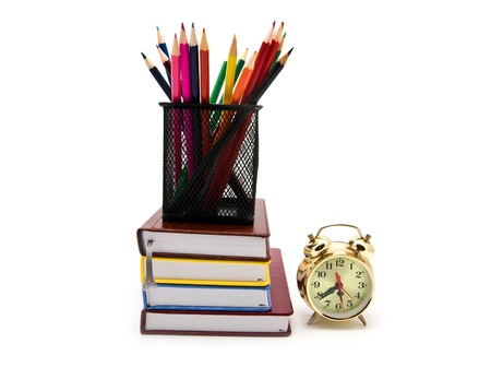books, clock and pencils on a white backgroundの写真素材