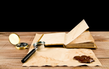 old paper, book, magnifying glass on a black backgroundの写真素材