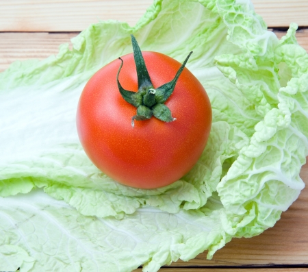 sheet of cabbage and tomato on a wooden backgroundの写真素材
