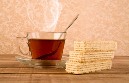 cup tea and waffles on a wooden tableの写真素材