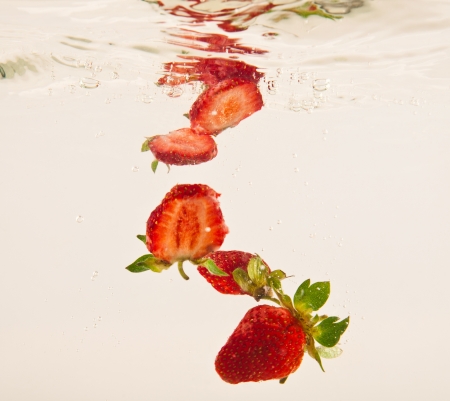 strawberry in clear water on a white backgroundの写真素材