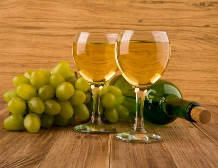 glass and bottle with wine on a wooden tableの写真素材