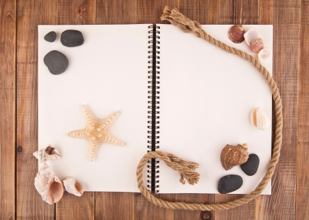 paper for a record with cockleshells and stone on a wooden backgroundの写真素材