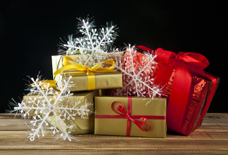branch of fir-tree, snowflakes and gifts on a black backgroundの写真素材