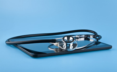 stethoscope and tablet on blue background closeupの写真素材