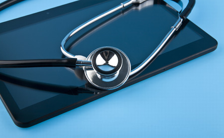 stethoscope and tablet on blue background closeupの写真素材