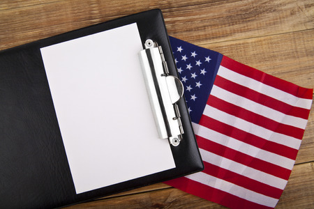 blank clip board and USA flag on wooden backgroundの写真素材