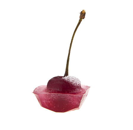 red cherry is in ice isolated on white background closeupの写真素材