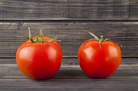 red, juicy tomatoes on a wooden backgroundの写真素材