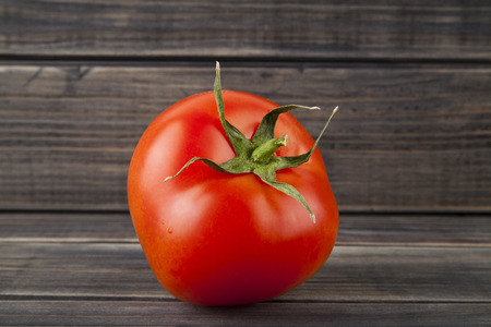 red, juicy, fresh tomatoes on a wooden backgroundの写真素材
