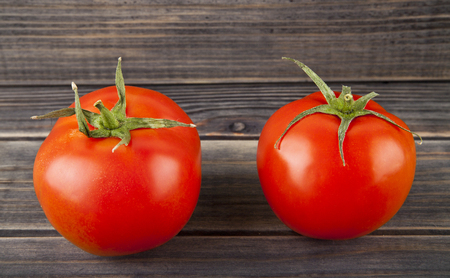 red, juicy, fresh tomatoes on a wooden backgroundの写真素材
