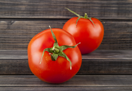 red, juicy, fresh tomatoes on a wooden backgroundの写真素材