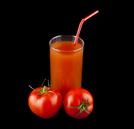 tomato juice in a glass and tomatoes on a black backgroundの写真素材