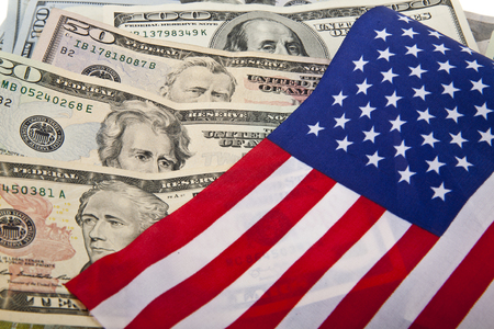 dollars and the US flag as a backgroundの写真素材