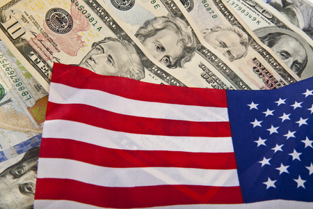dollars and the US flag as a backgroundの写真素材