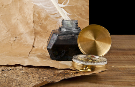 old paper and inkwell with a feather on black backgroundの写真素材