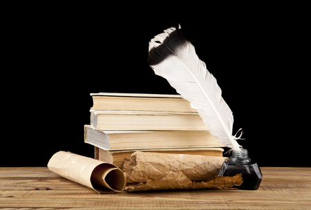 old paper, books and inkwell with a pen on a black backgroundの写真素材