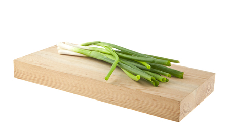 green onion on wooden board isolated on white backgroundの写真素材