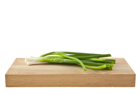 green onion on wooden board isolated on white backgroundの写真素材
