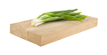 green onion on wooden board isolated on white backgroundの写真素材